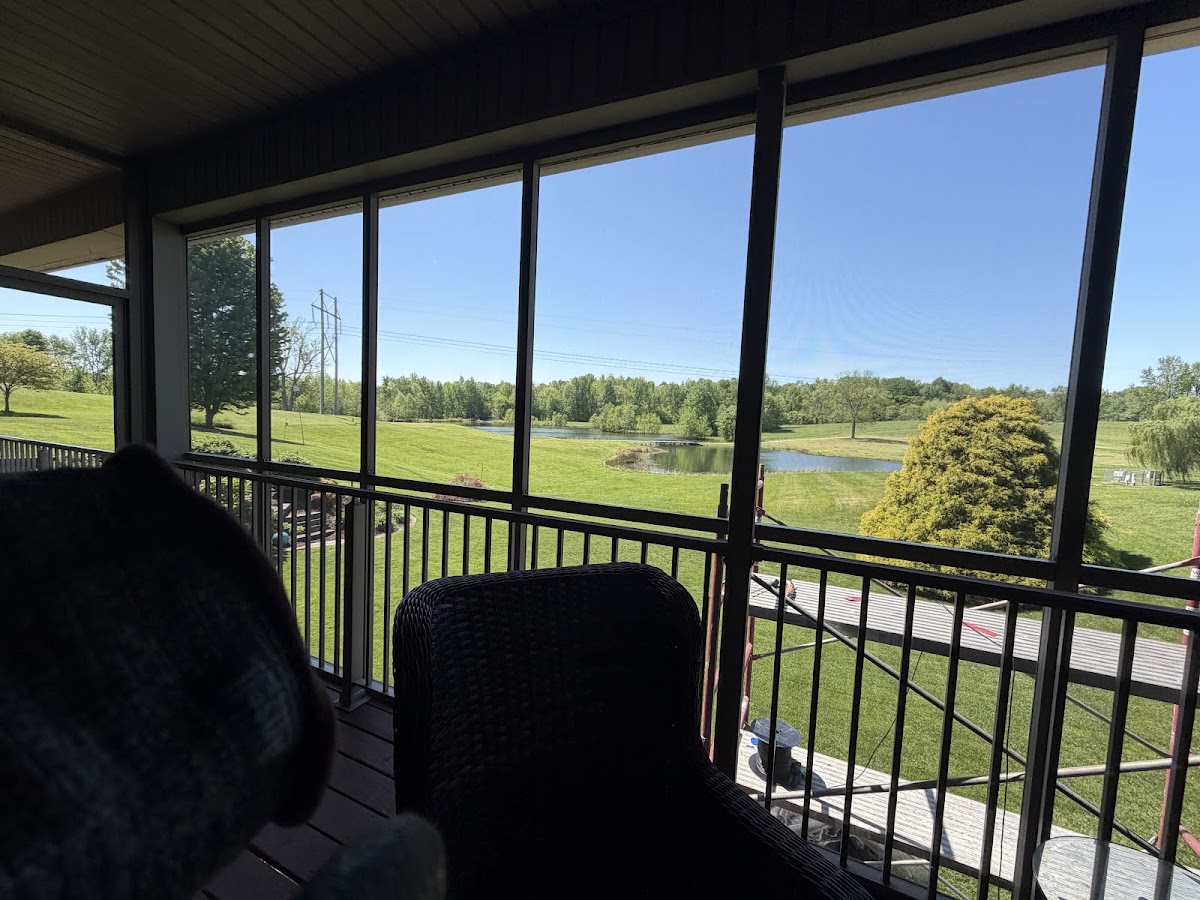 Screened porch looking out over a yard and pond